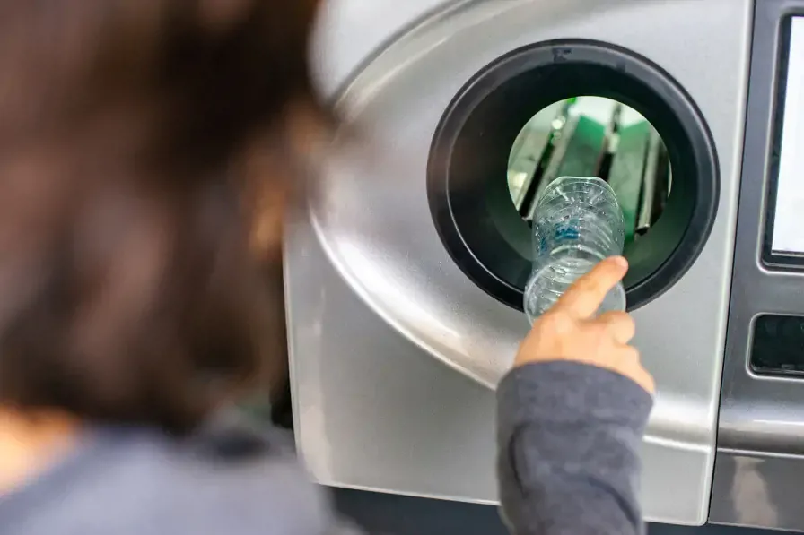 Deposit Return Scheme Empty Bottle placed into reverse vending machine