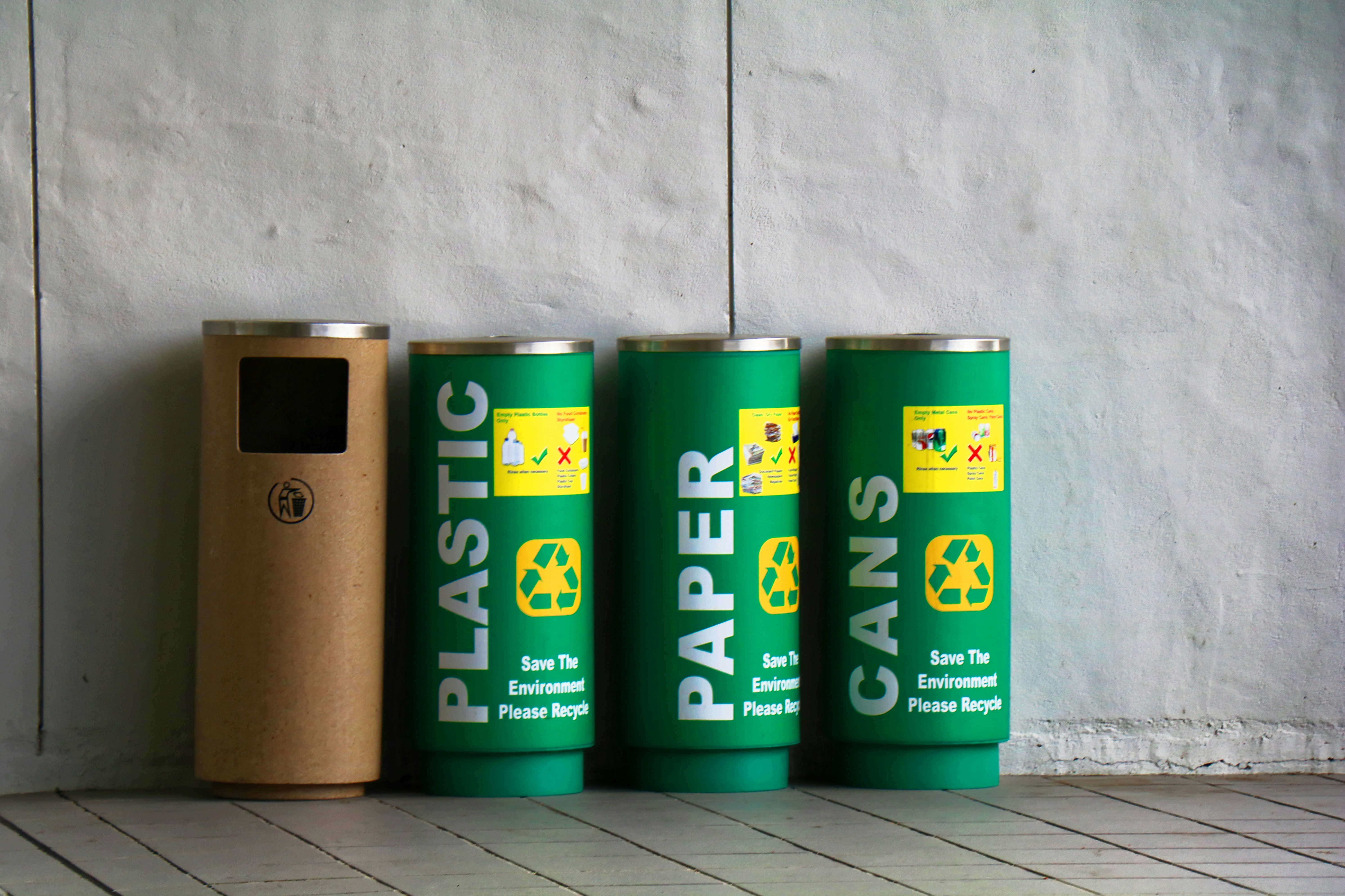 three green recycling bins and one brown